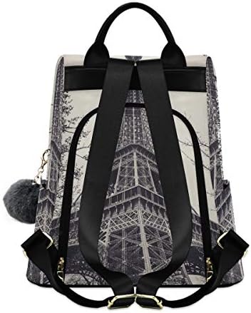 Torre Alaza Eiffel cercada por galhos de árvores e galhos de mochila ao ar livre para mulher