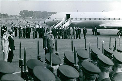 Foto vintage de Charles de Gaulle, olhando para homens militares em um aeroporto.