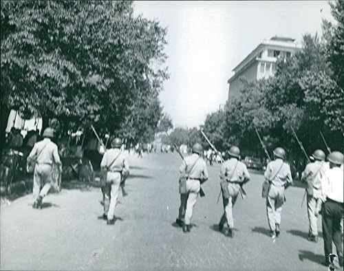 Foto vintage de soldados marchando ao longo da rua.